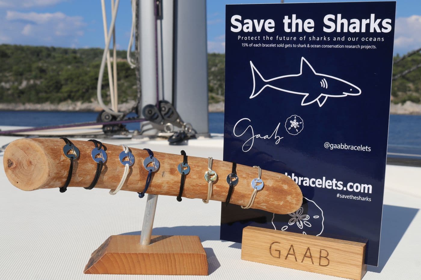 Save the Sharks display card and driftwood bracelet stand on a sailboat